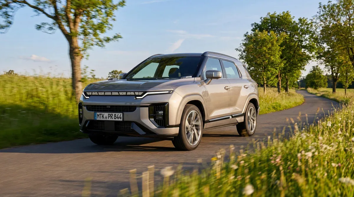 Grey KGM Actyon driving on a tree-lined country road