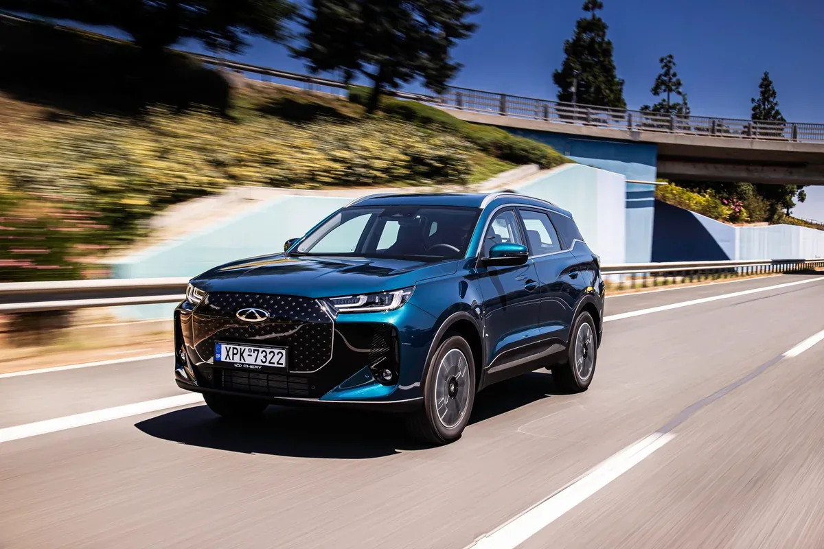 Dark blue Chery TIGGO 7 PHEV driving on a sunlit road