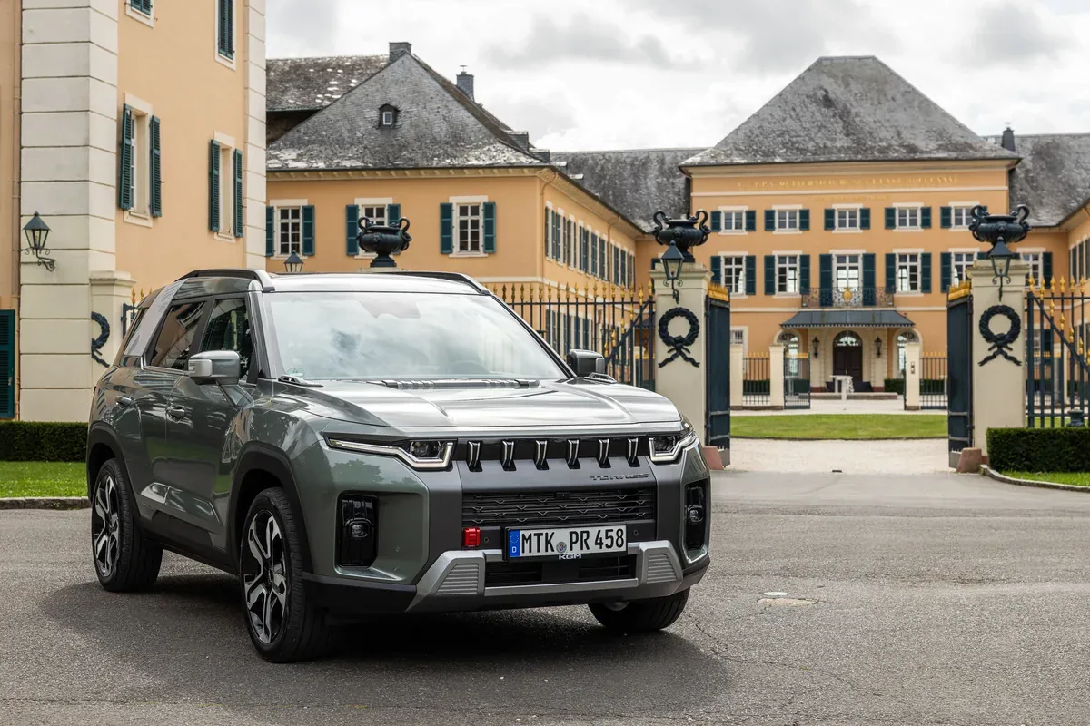 Grey KGM Torres parked outside a country house