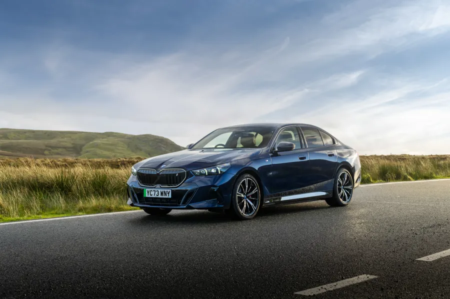 Electric executive saloon in blue on an open moorland road