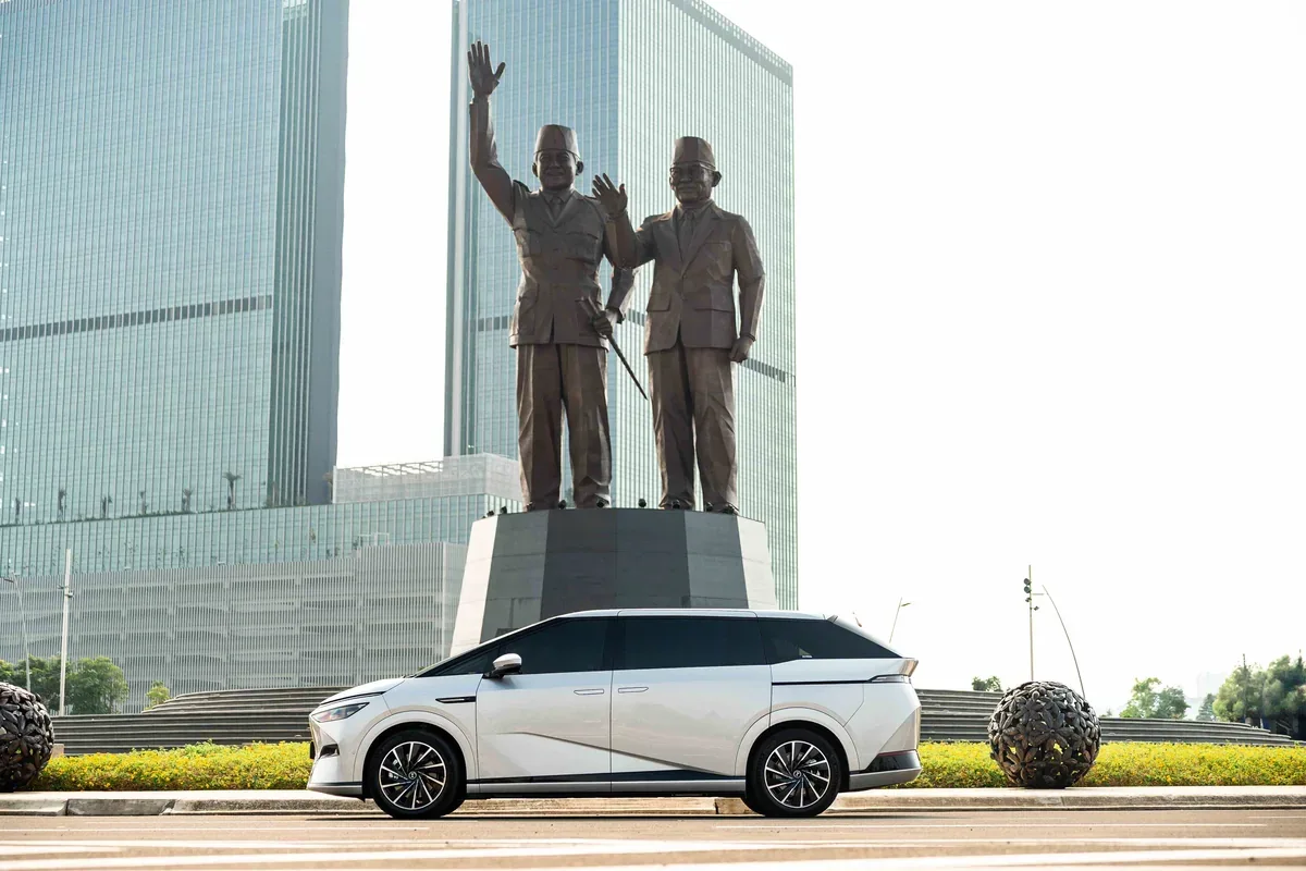 White XPENG X9 parked in front of a city monument