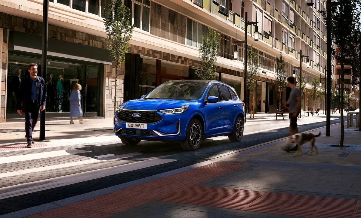 Blue facelifted Ford Kuga ST-Line driving along a city street