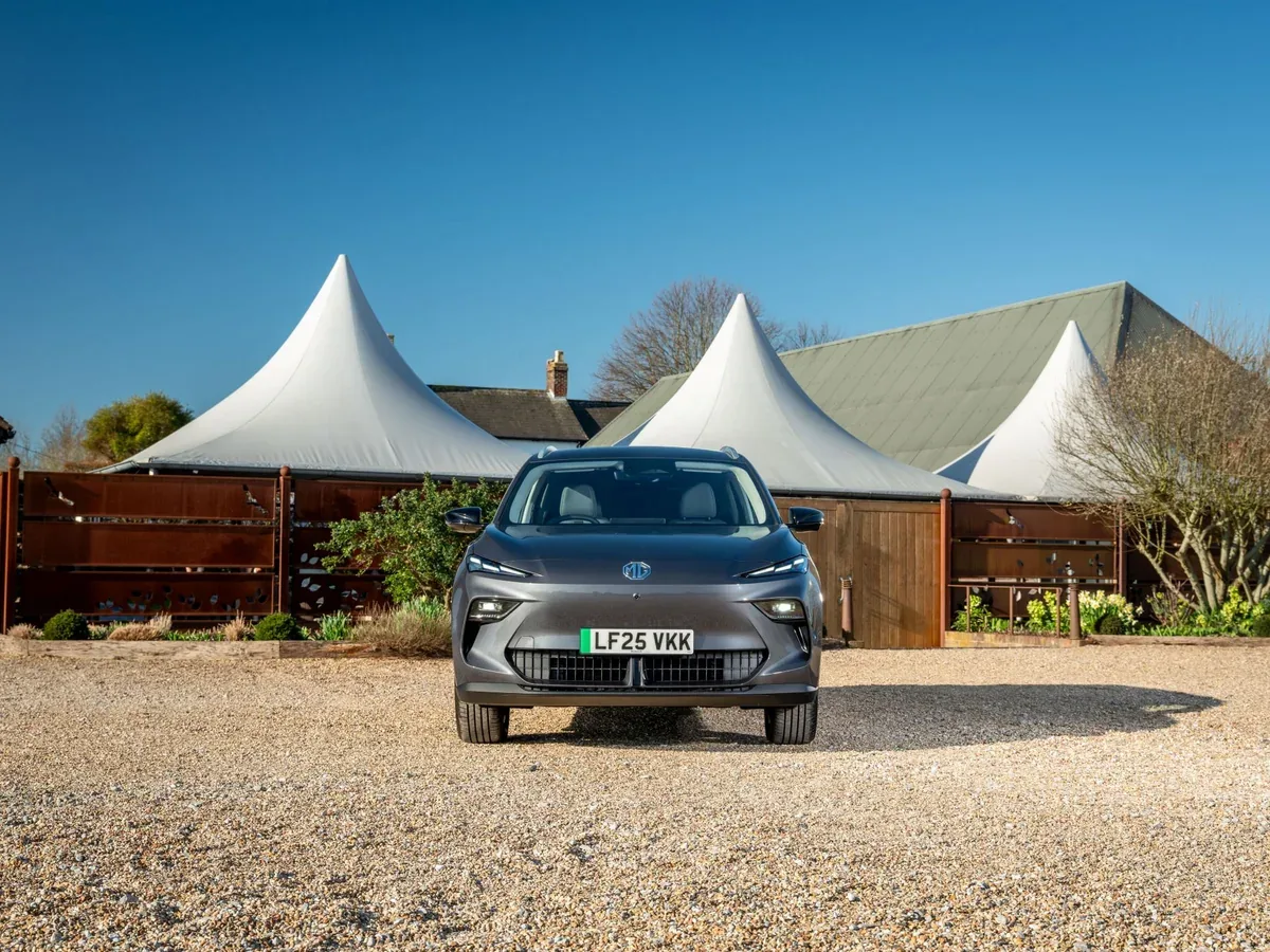 Grey MGS5 EV parked on gravel in front of white marquees