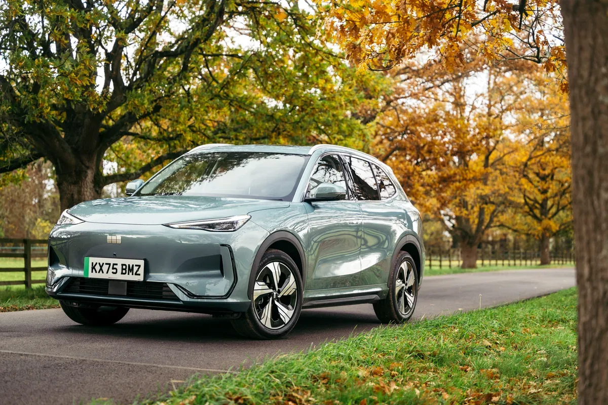 Grey Geely EX5 parked beside trees in autumn